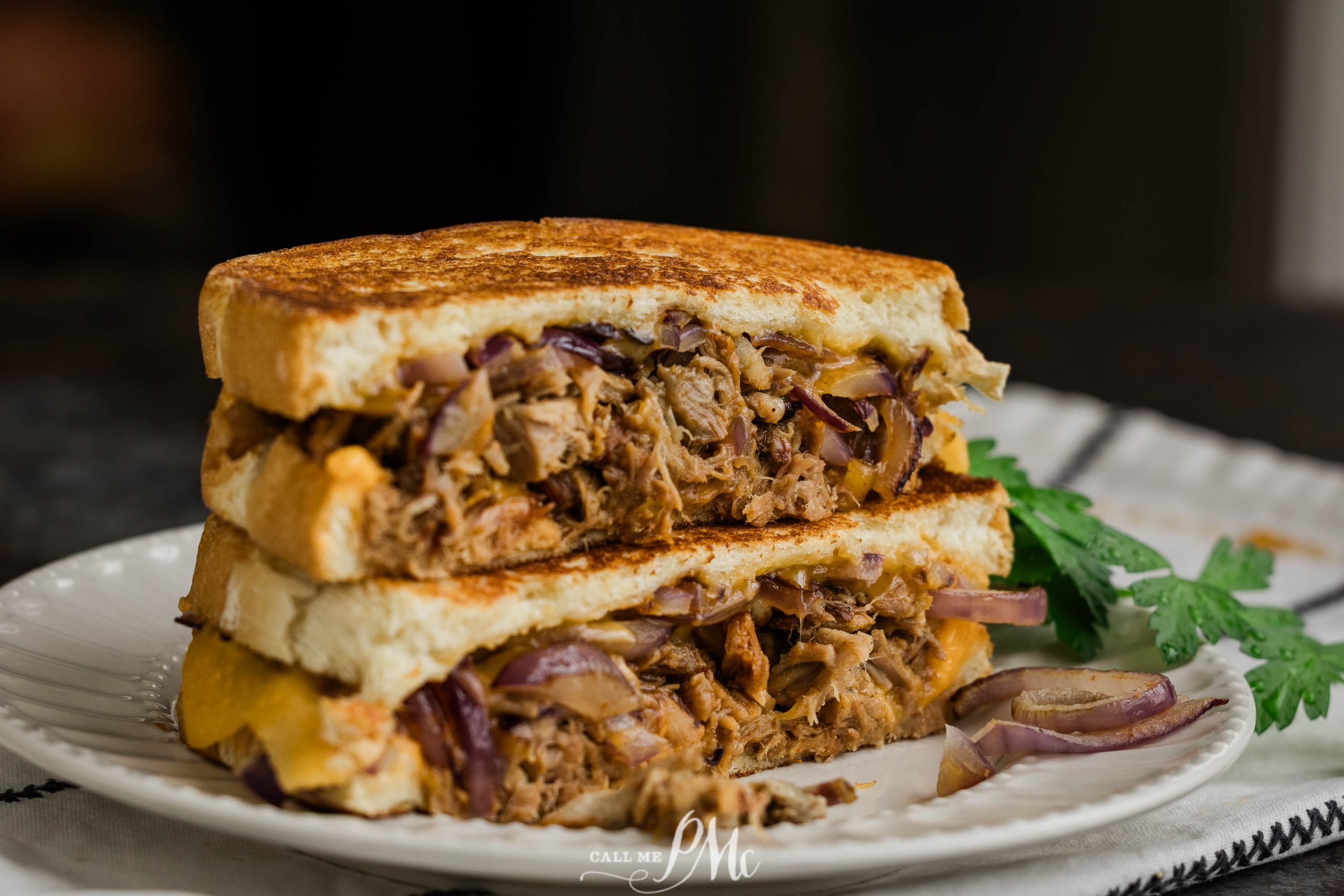 A stack of pulled pork grilled cheese on a plate.