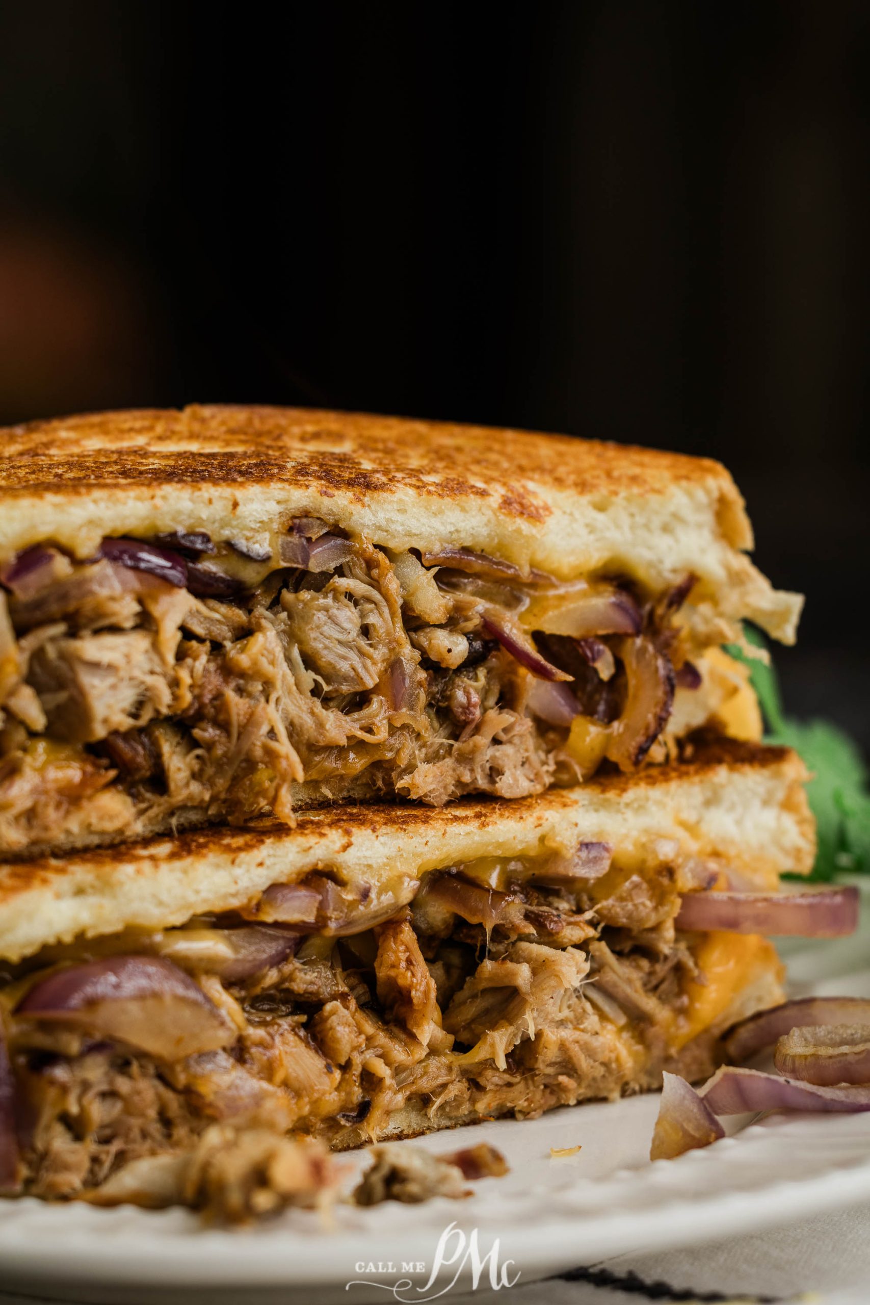 Pulled pork grilled cheese sandwich on a plate.