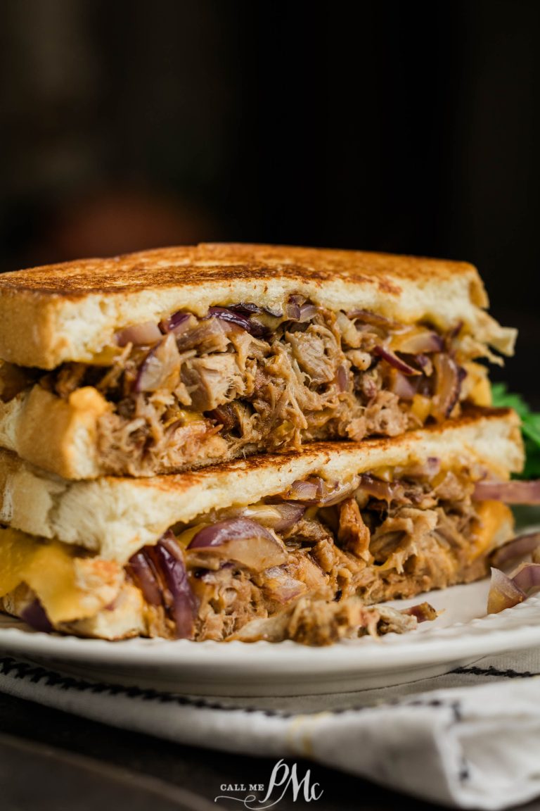 A grilled sandwich with pulled pork and onions on a plate.