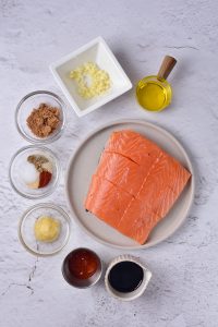 A plate with ingredients for a salmon recipe.