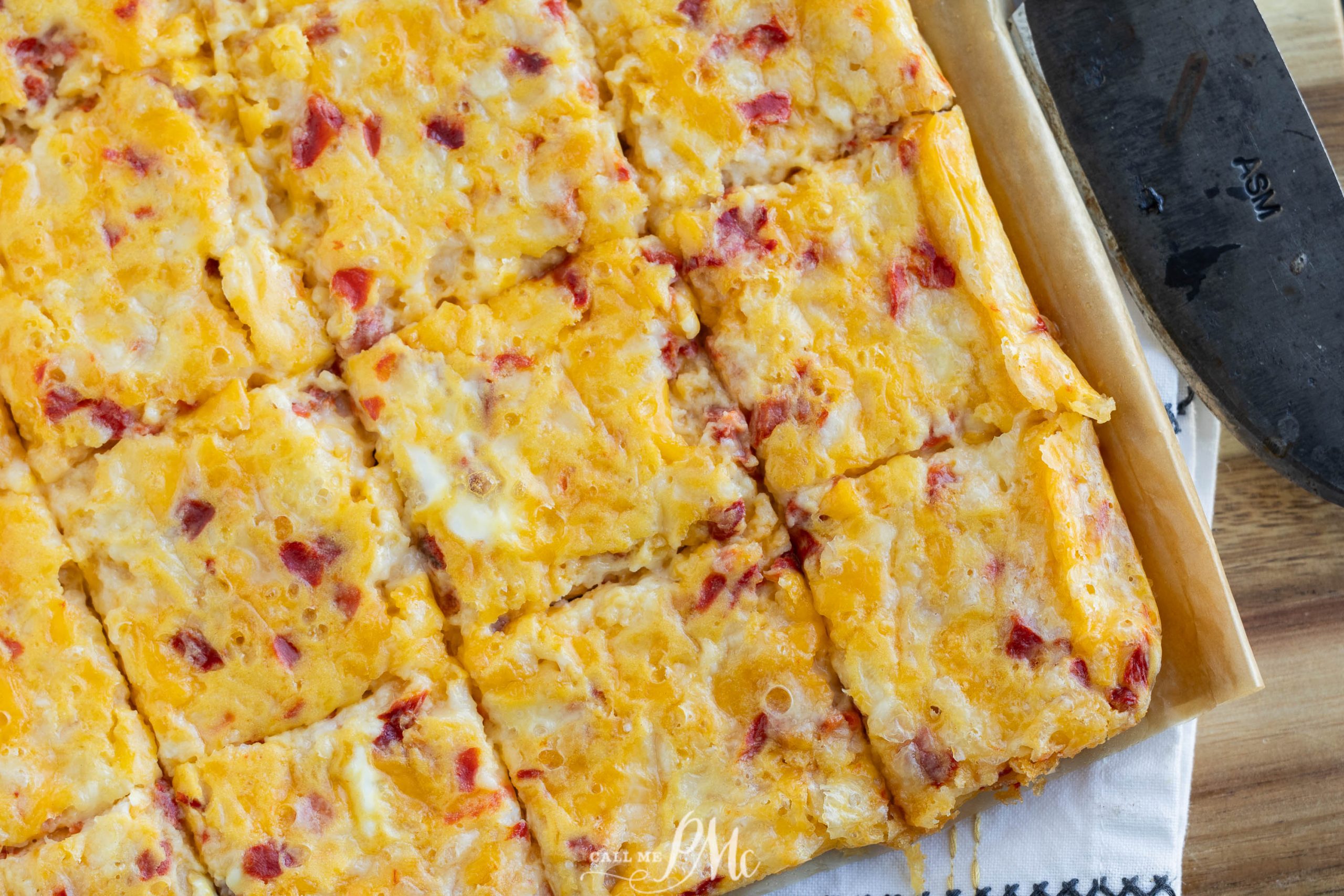 Cheesy breakfast bars on a wooden cutting board.