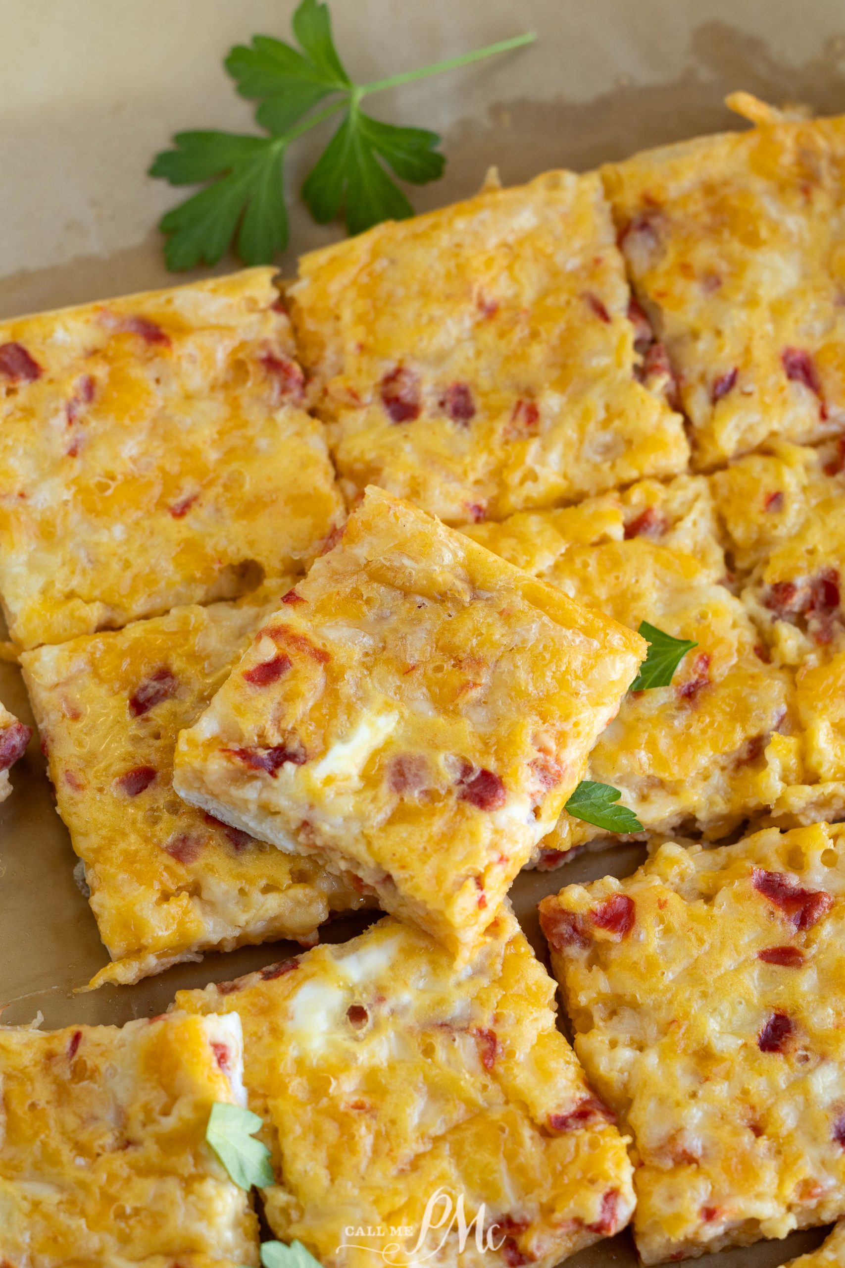 Pimento cheese squares on a brown tray.