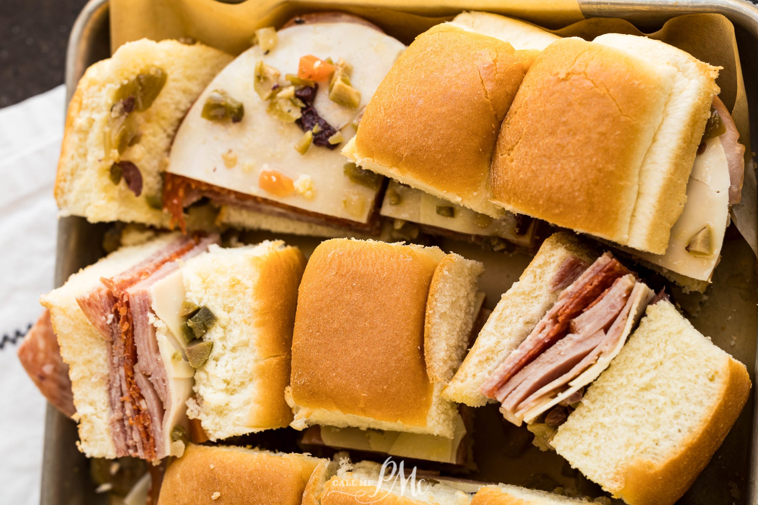 Ham and cheese sandwiches in a pan with a napkin.