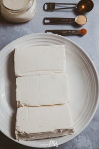 A white plate with three pieces of cheese on it.