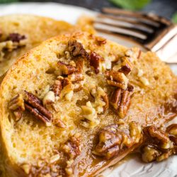 French toast with pecans and maple syrup on a plate.