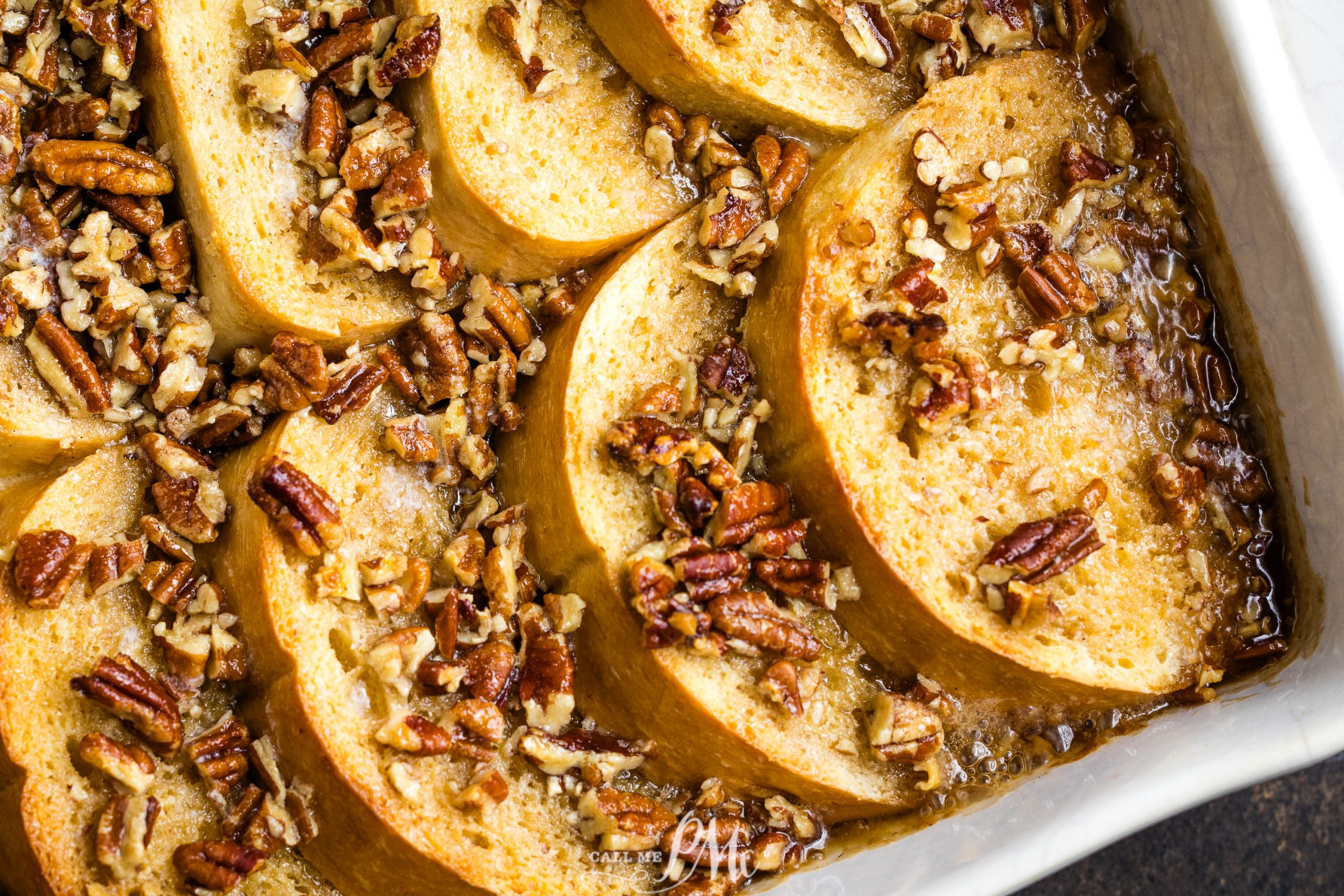 A casserole dish with sliced apples and pecans.