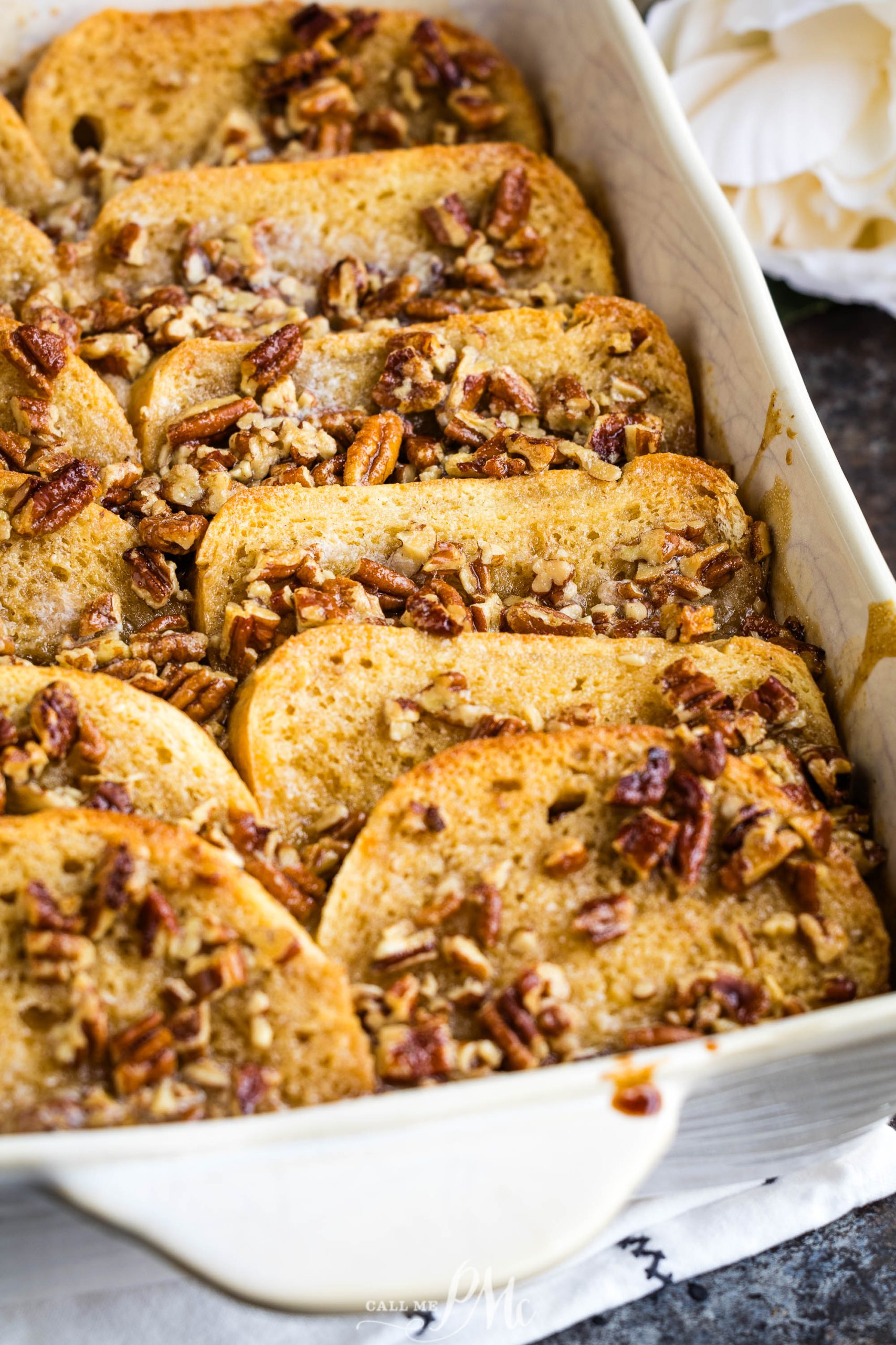 French toast casserole with pecans in a white dish.
