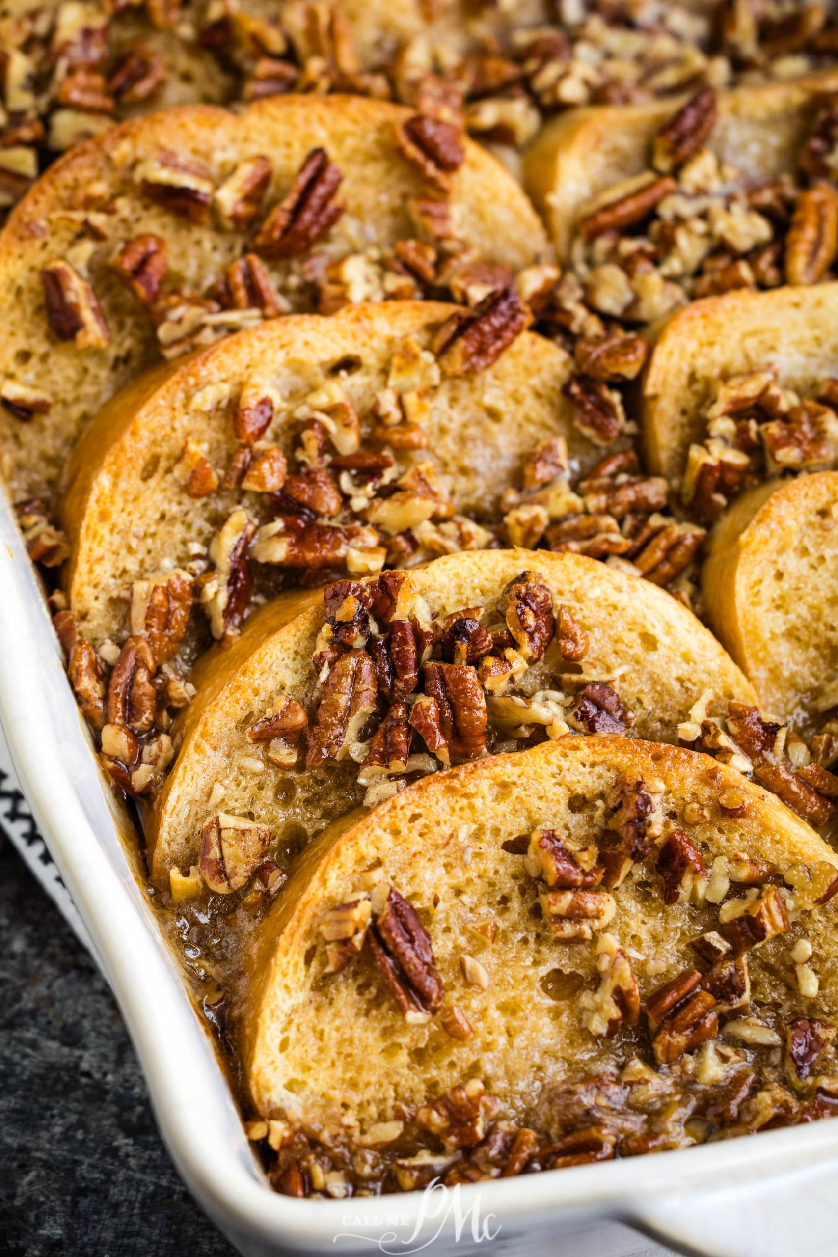 French toast casserole with pecans in a white dish.