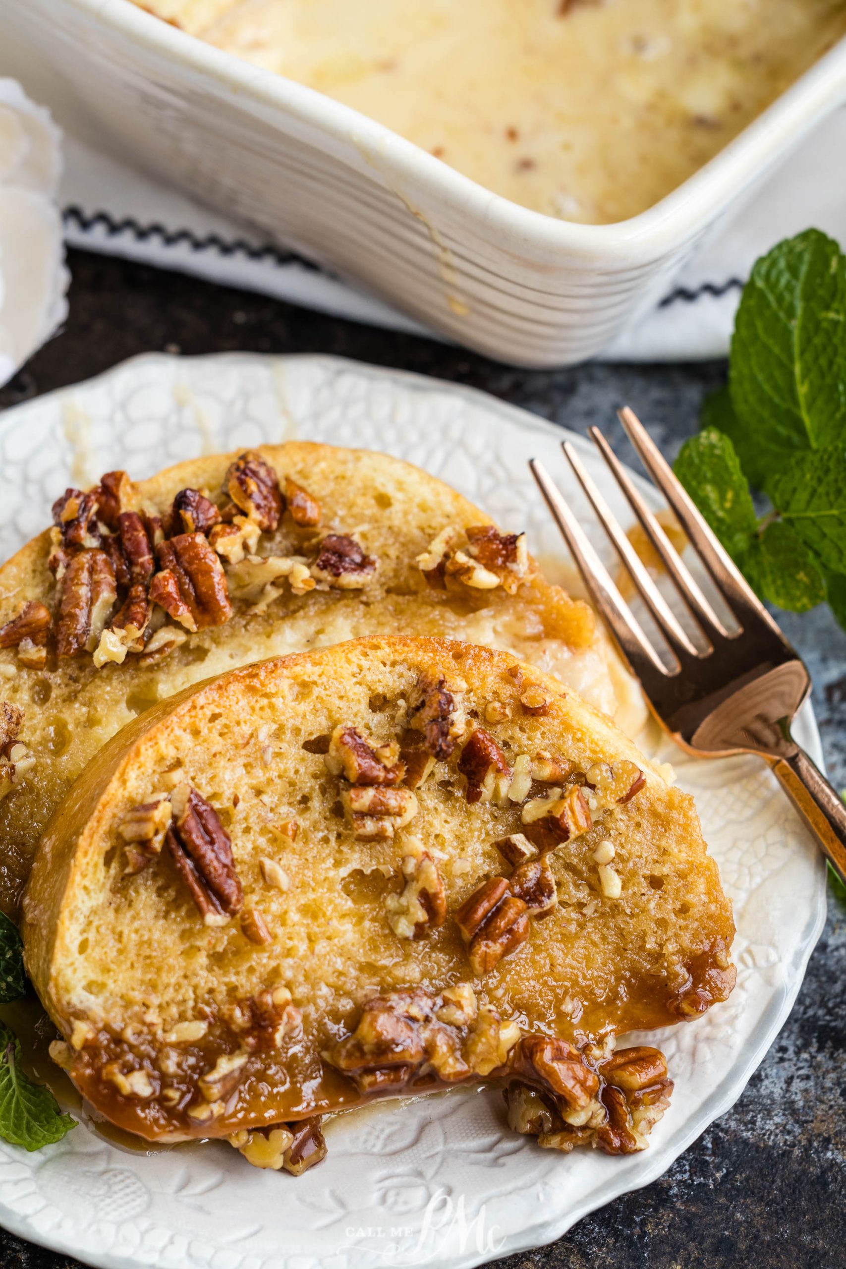 French toast casserole with pecans on a white plate.