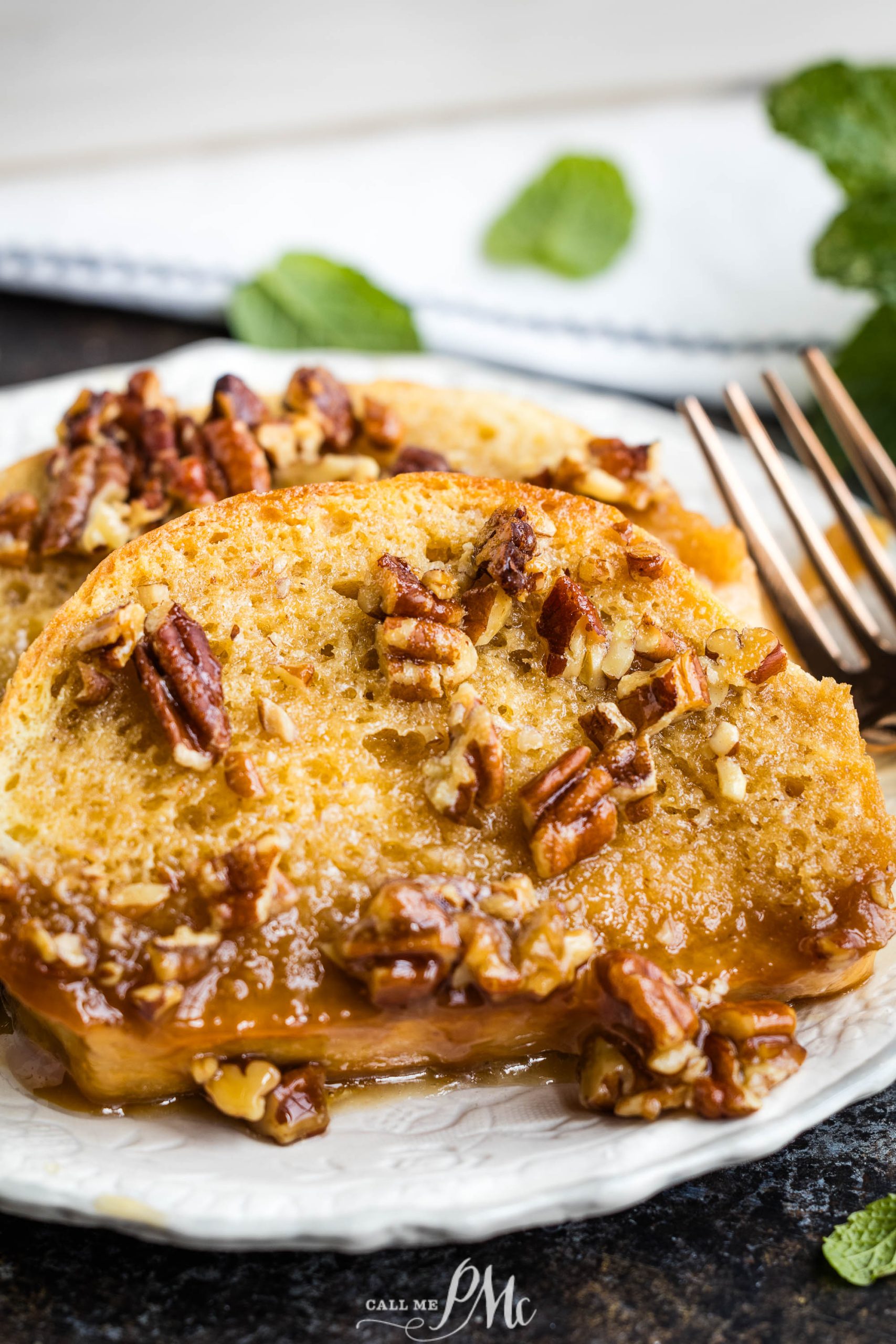 French toast with pecans and maple syrup on a plate.