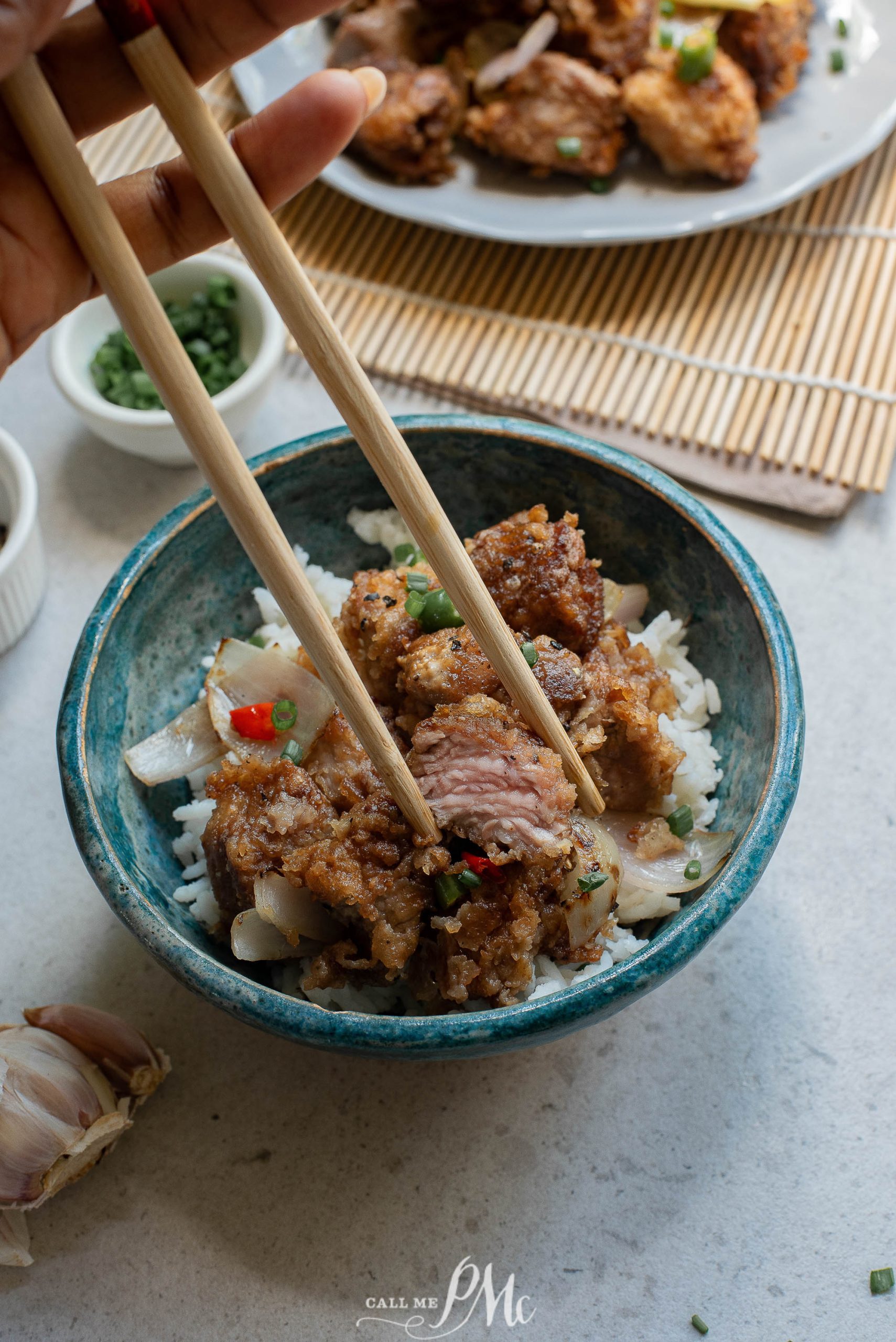 A person holding chopsticks over a bowl of Panko Parmesan Pork Nuggets