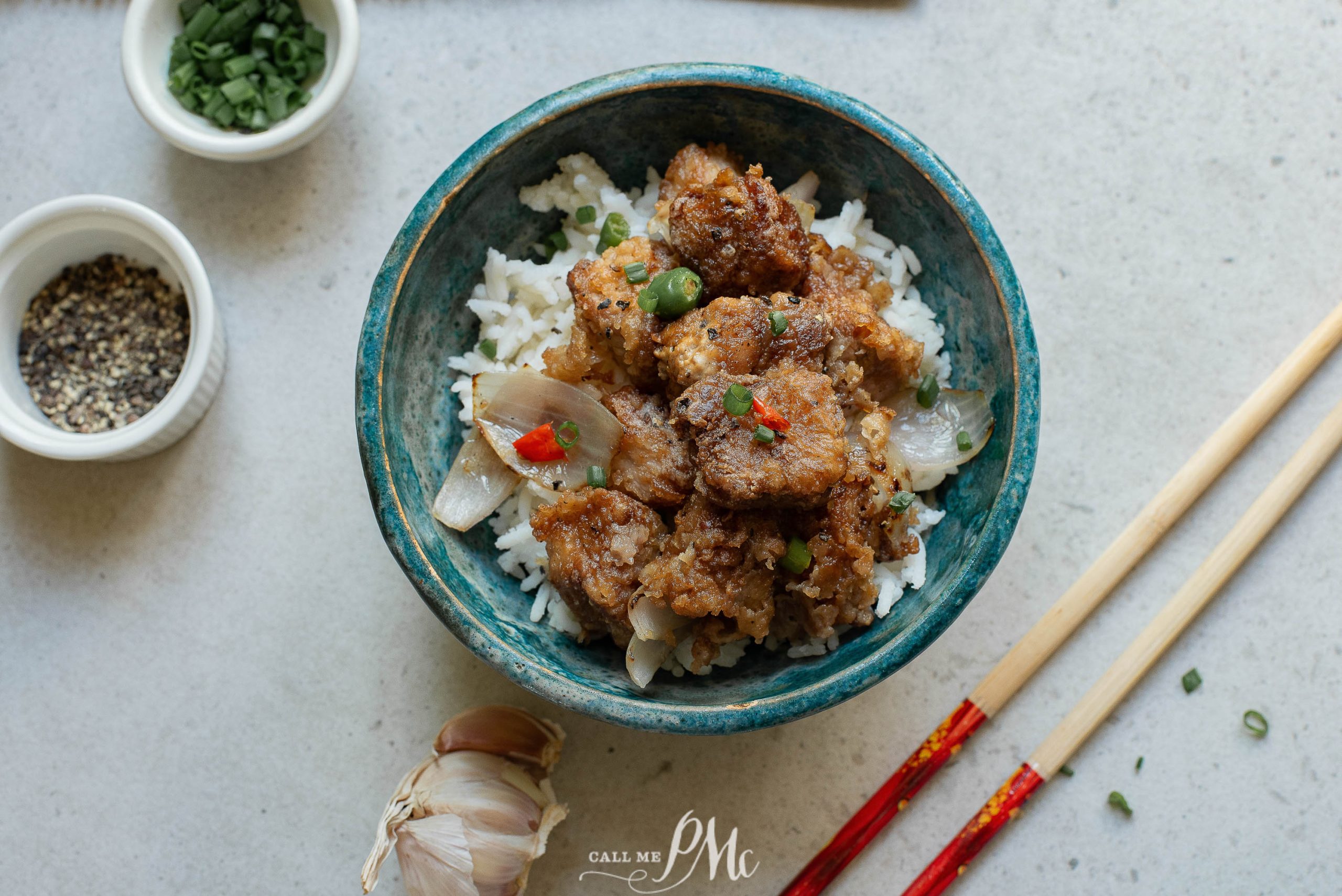 Chinese fried rice with chicken in a blue bowl with chopsticks.