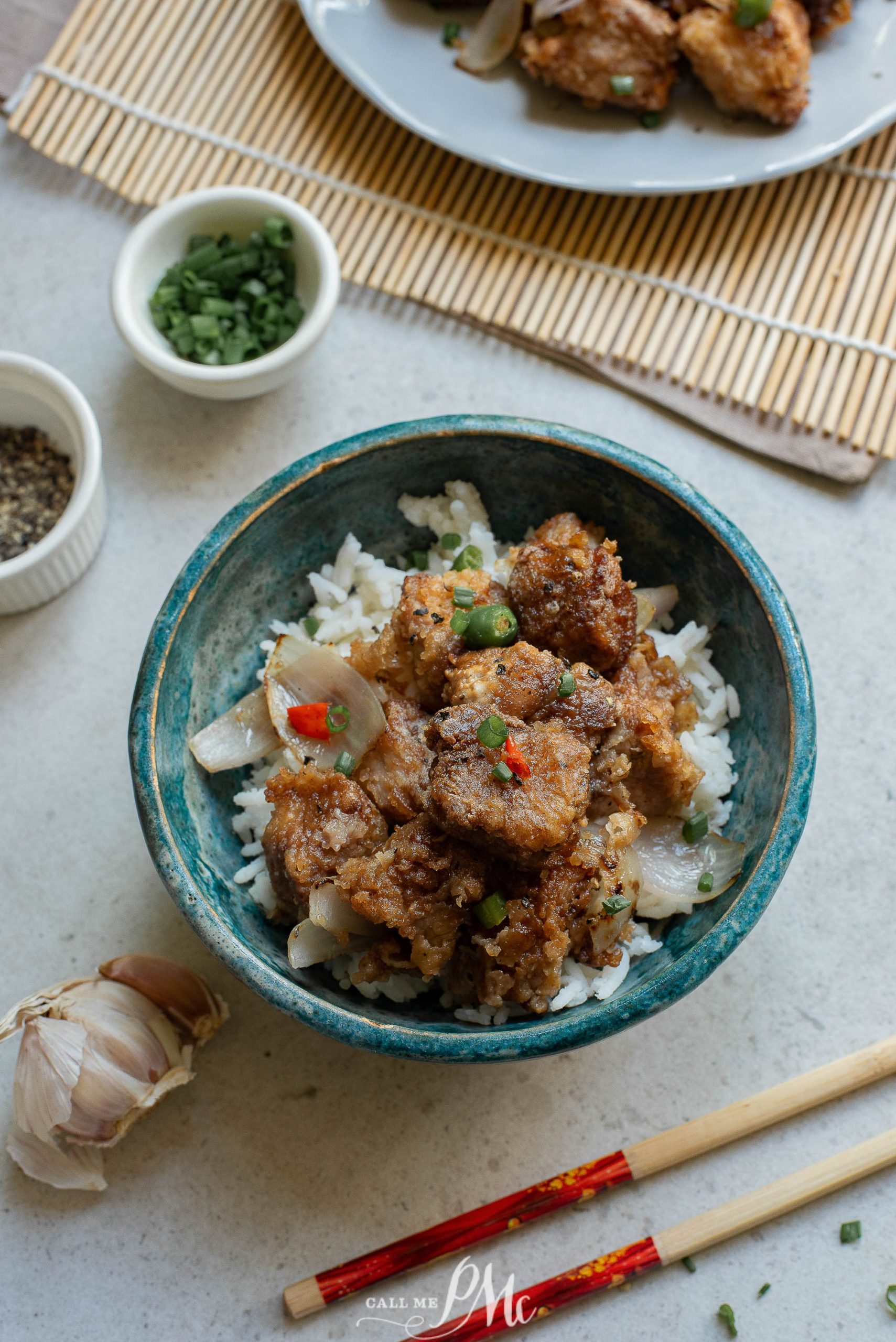 A bowl of Panko Parmesan Pork Nuggets with rice and chopsticks.