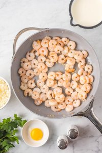 A frying pan with shrimp, eggs and other ingredients.