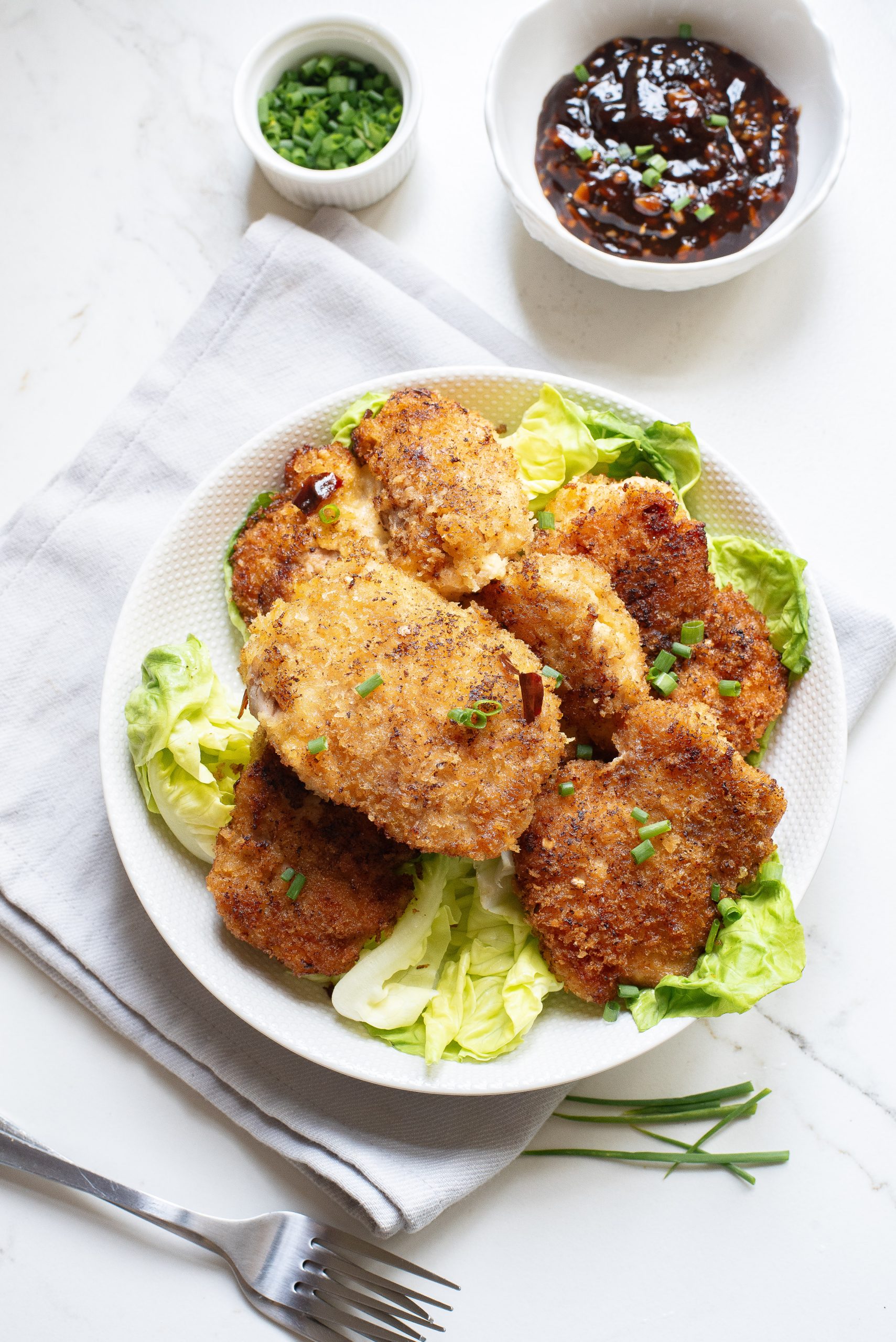 A plate with Sticky Thai Chicken Thighs and salad on it.