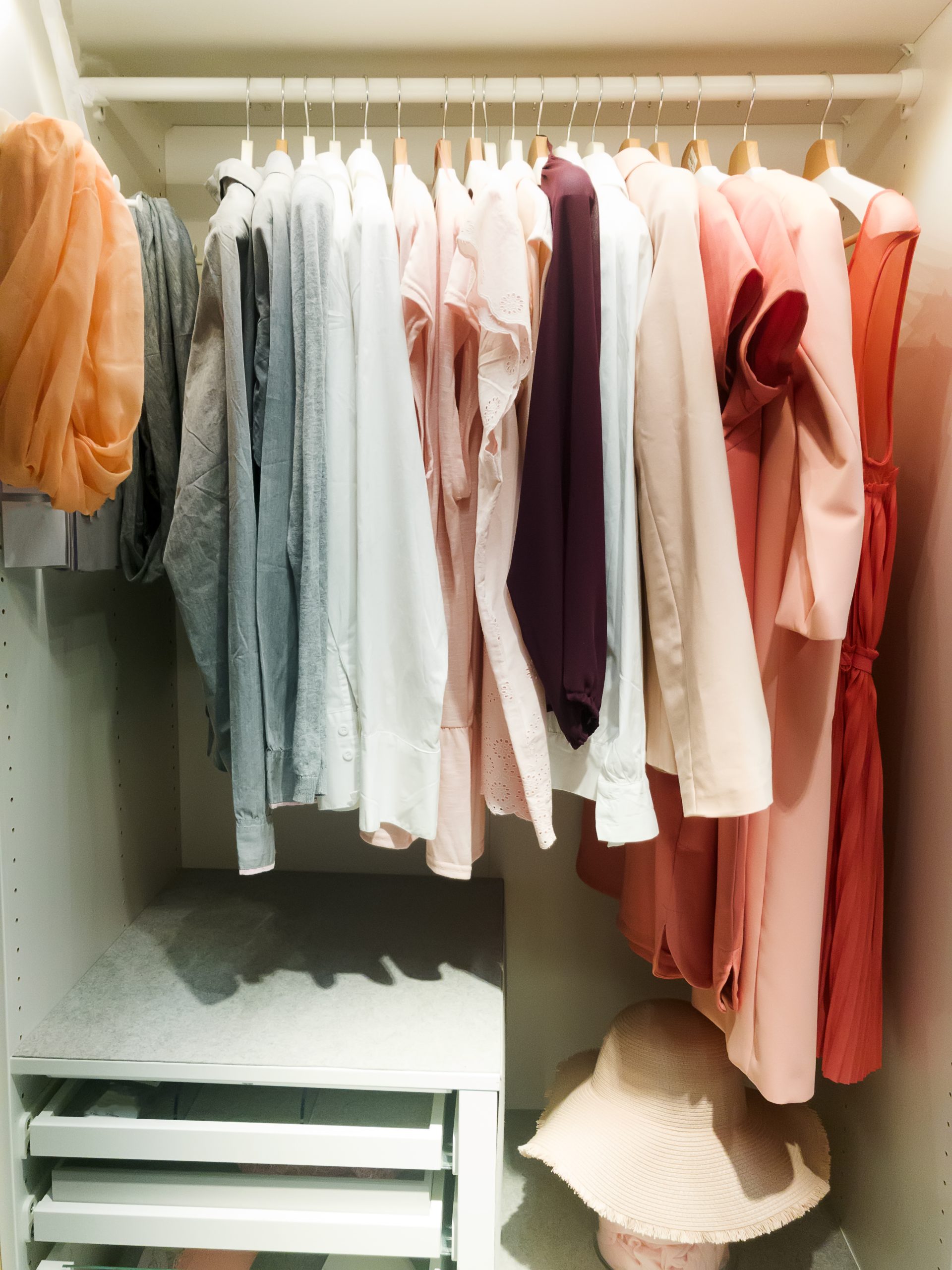 A closet with clothes on swingers.