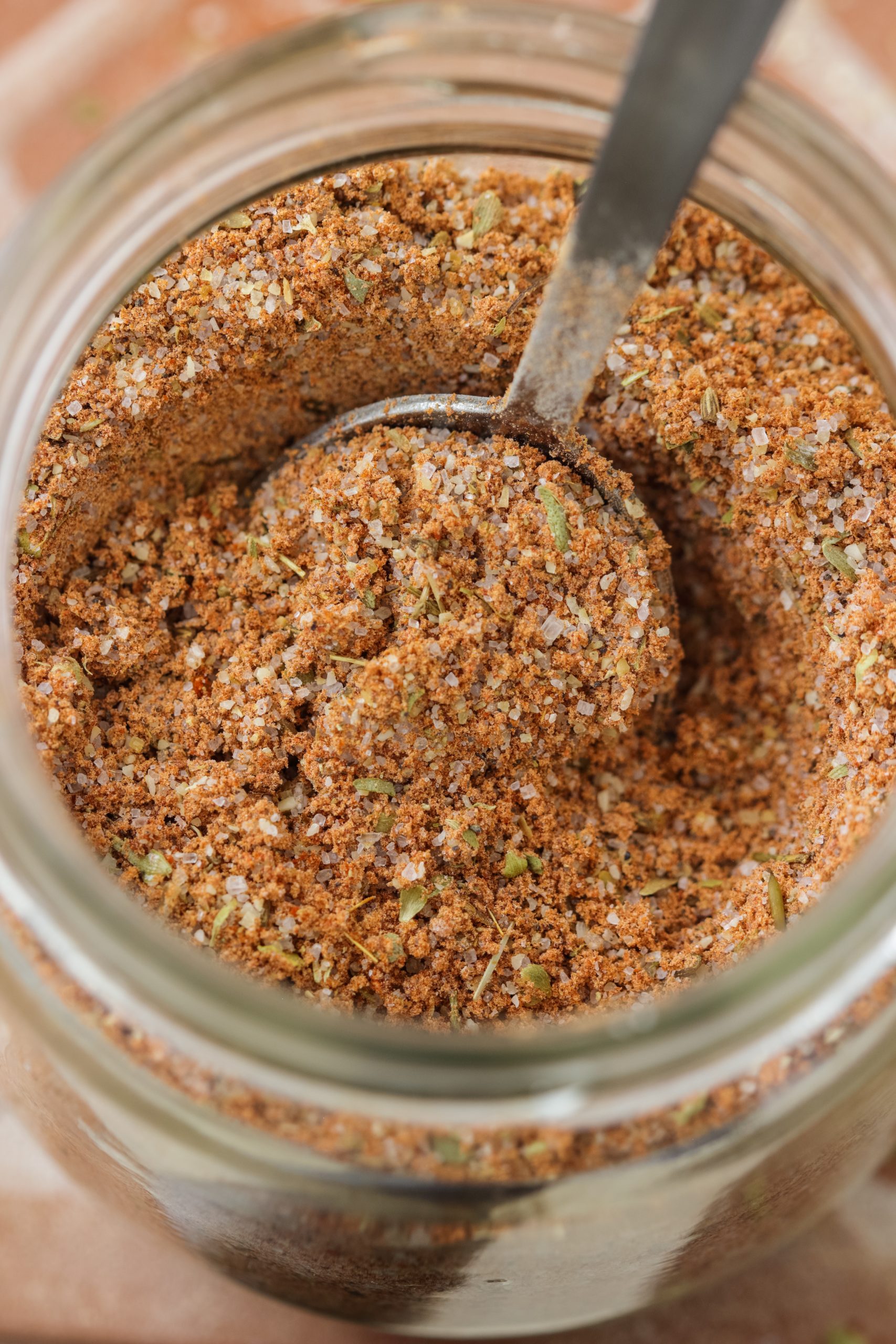 A jar of Homemade Fajita Seasoning with a spoon in it.