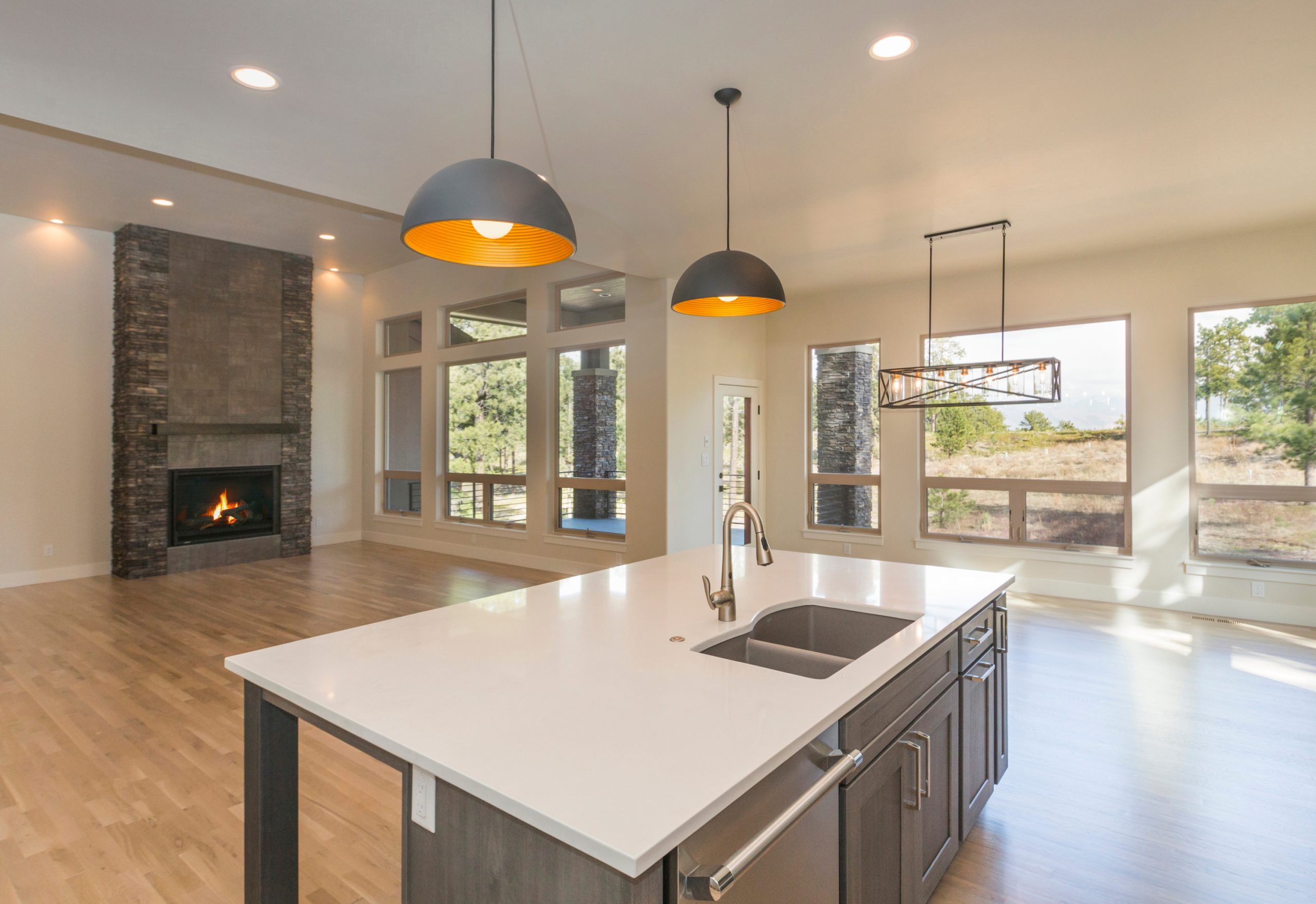 An open kitchen with hardwood floors and a fireplace.