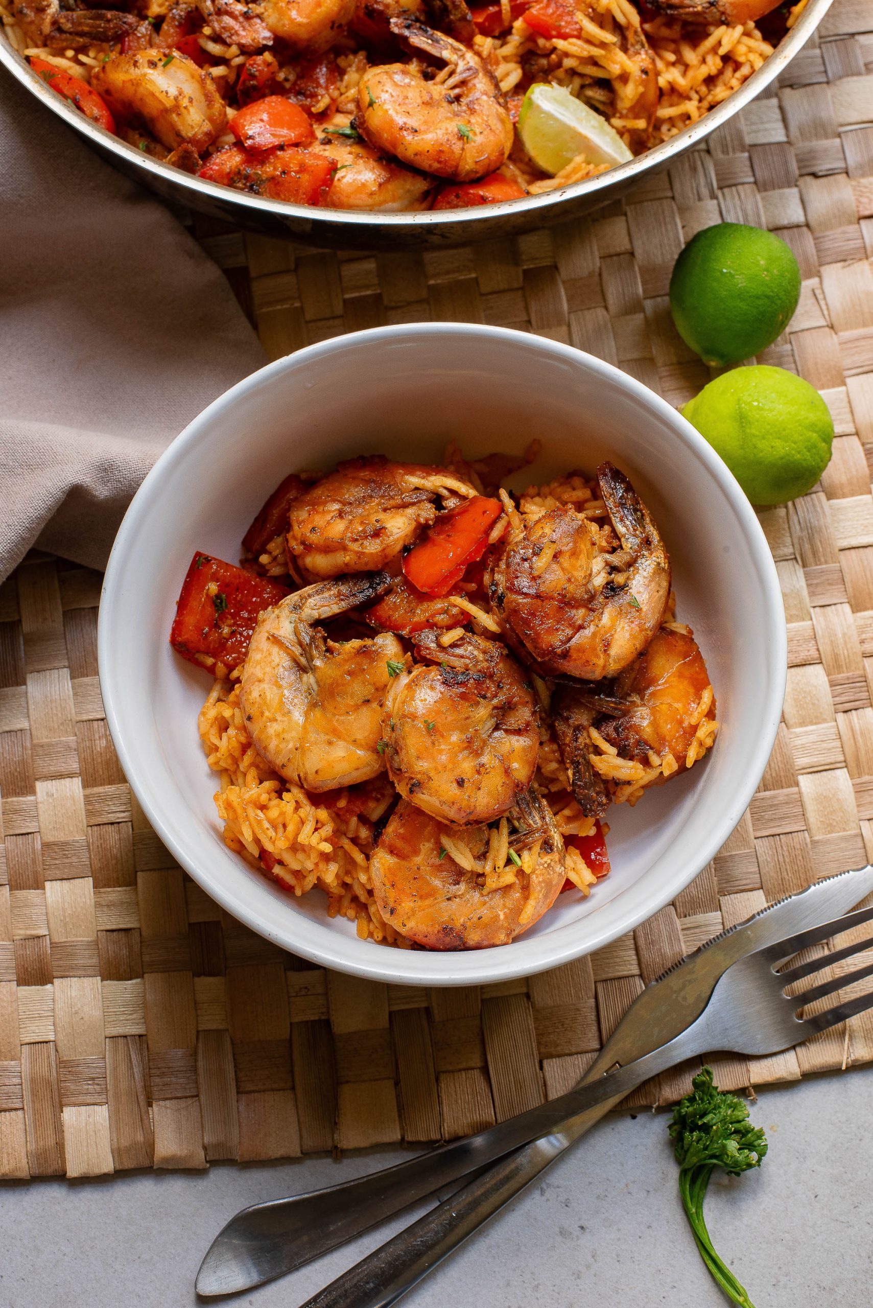 A bowl of rice and shrimp on a table.