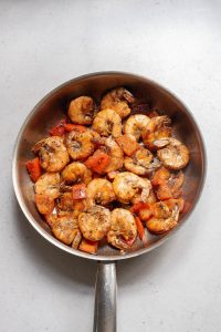 A frying pan full of shrimp and vegetables.