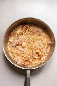 A pan of rice and onions.