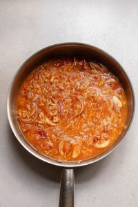 A pot of food with a sauce.