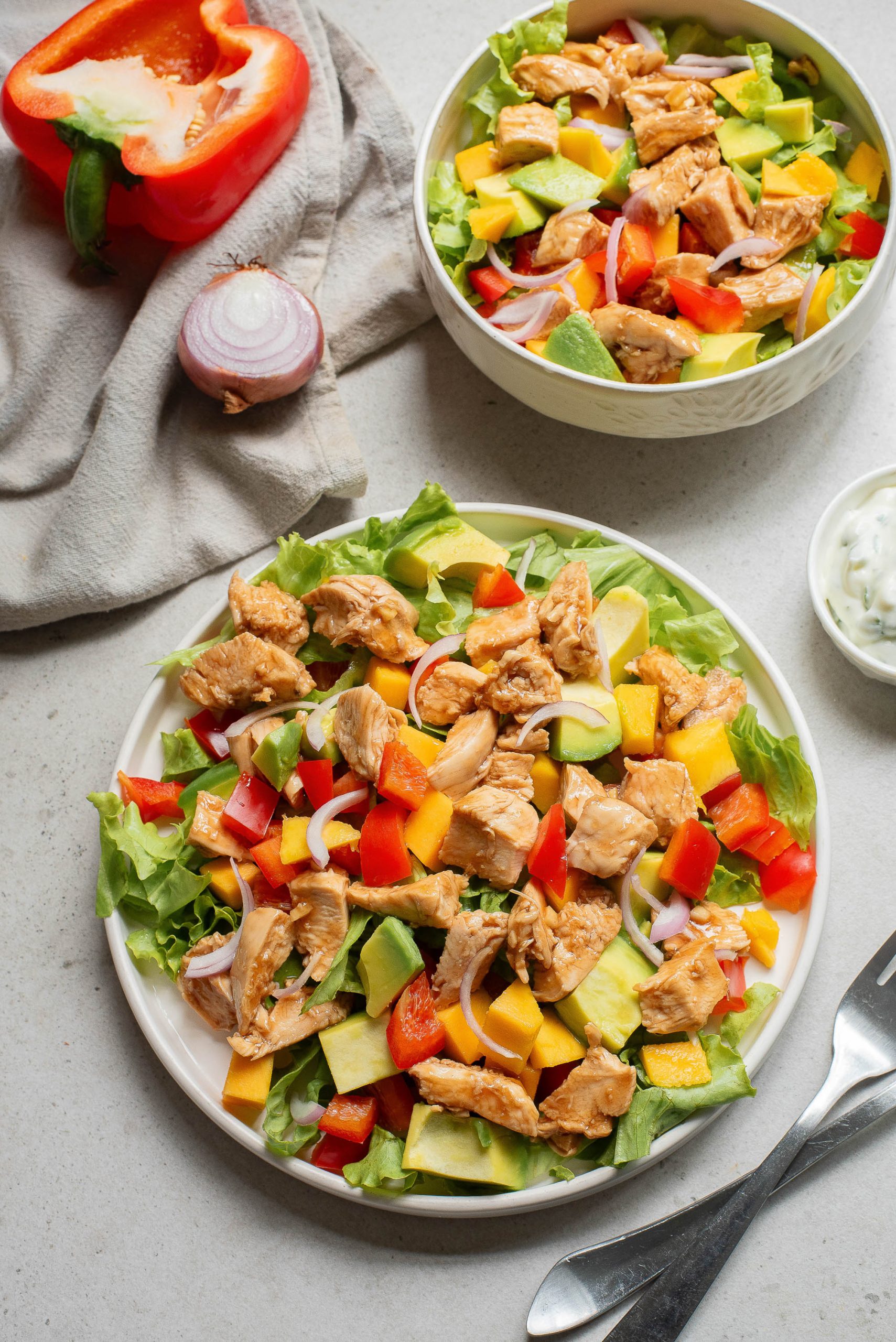 A plate of salad with chicken and vegetables.