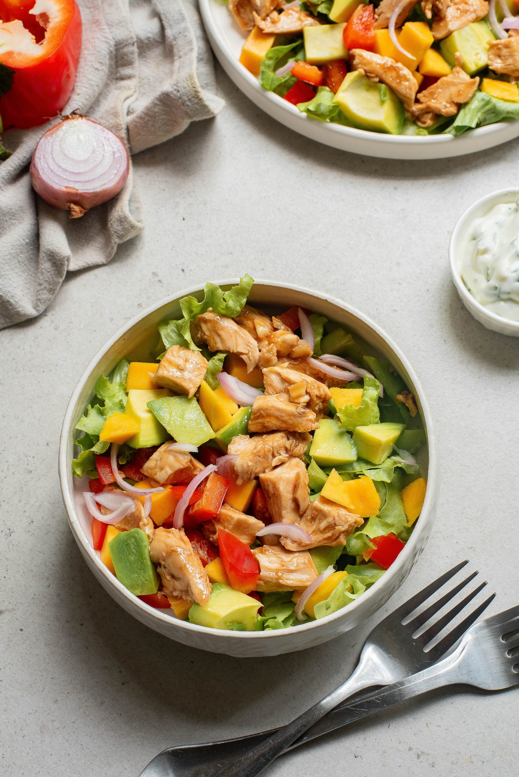 A bowl of salad with meat and vegetables.