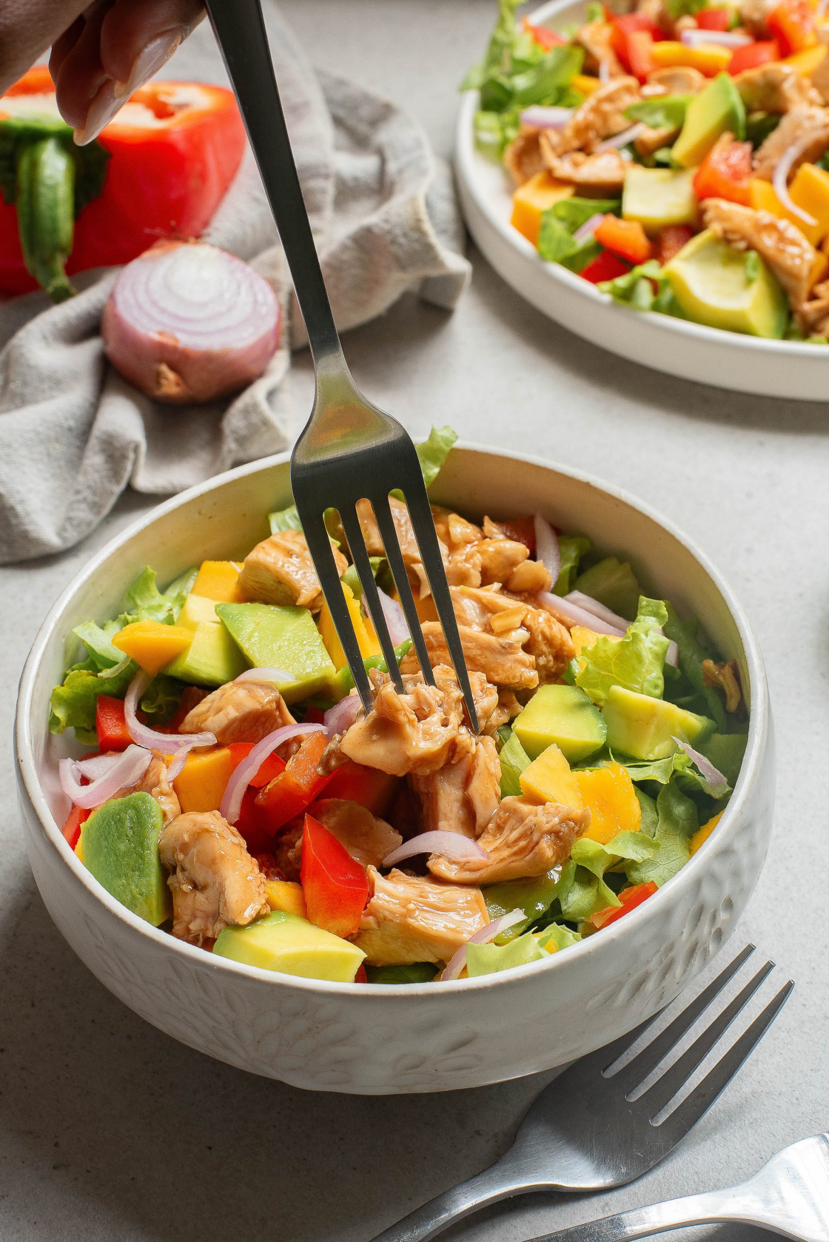 A bowl of salad with a fork.