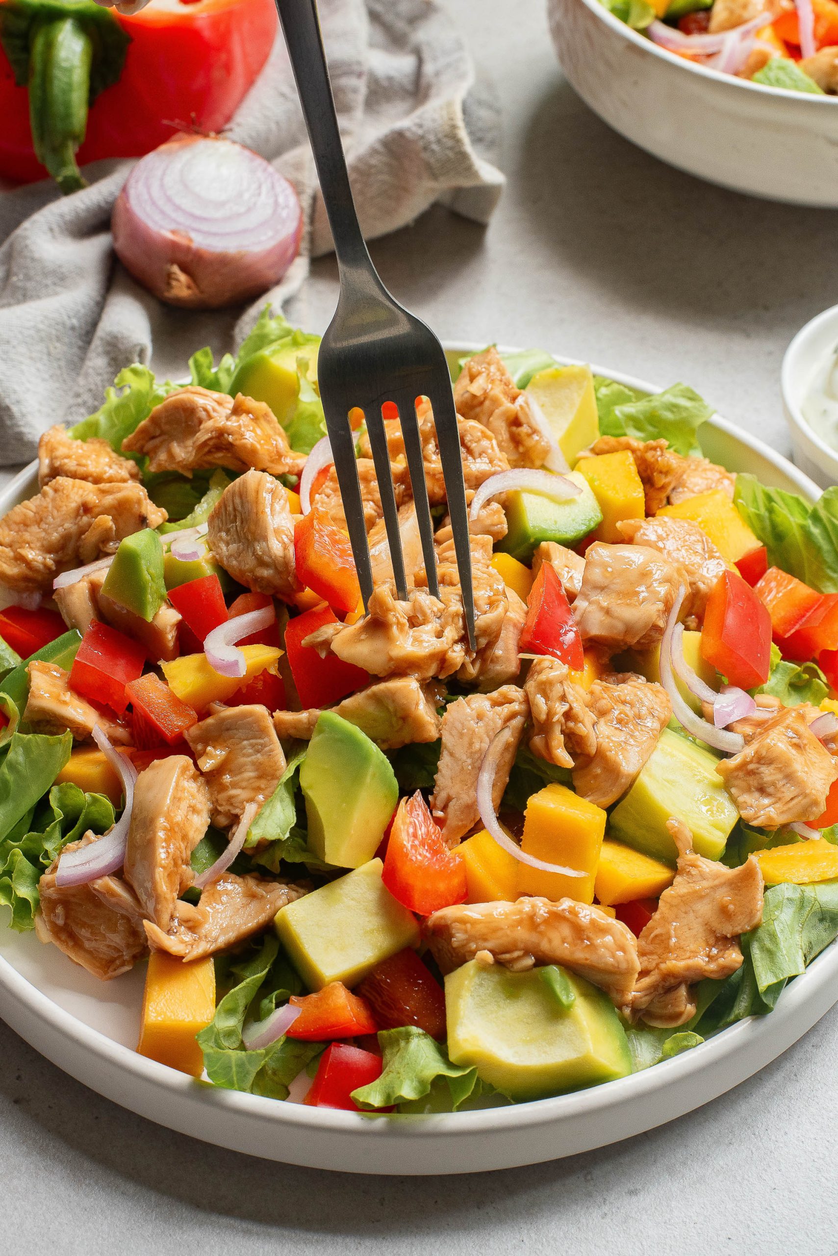 A fork in a bowl of salad.