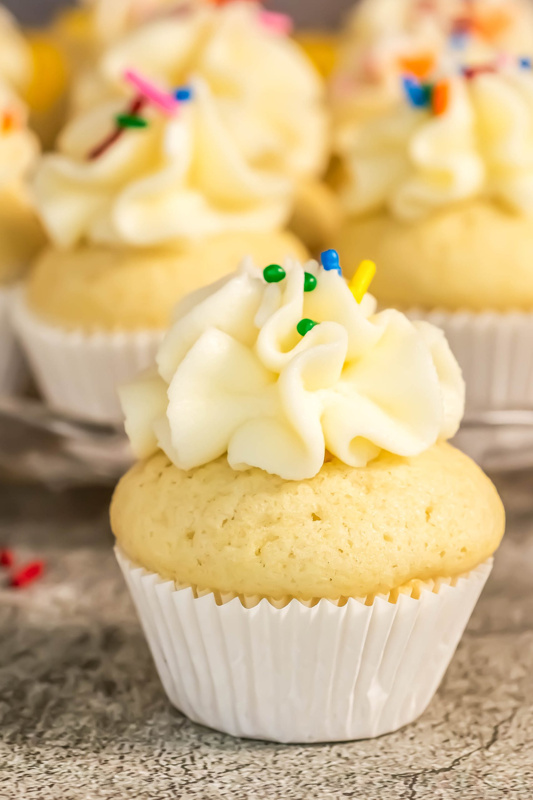 Cupcakes with icing and sprinkles on a plate.