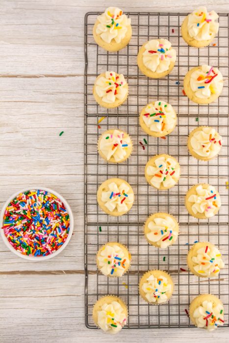 A rack of Classic Vanilla Cupcake with sprinkles on it.