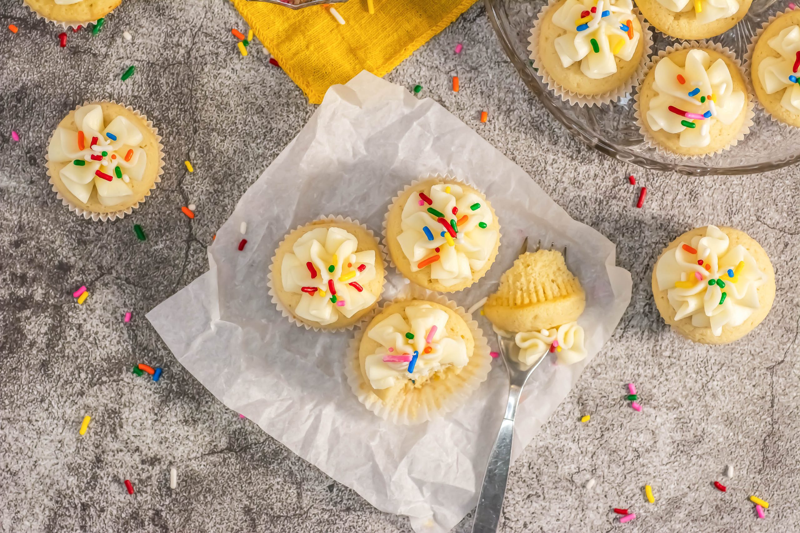 A Classic Vanilla Cupcake with frosting and sprinkles.