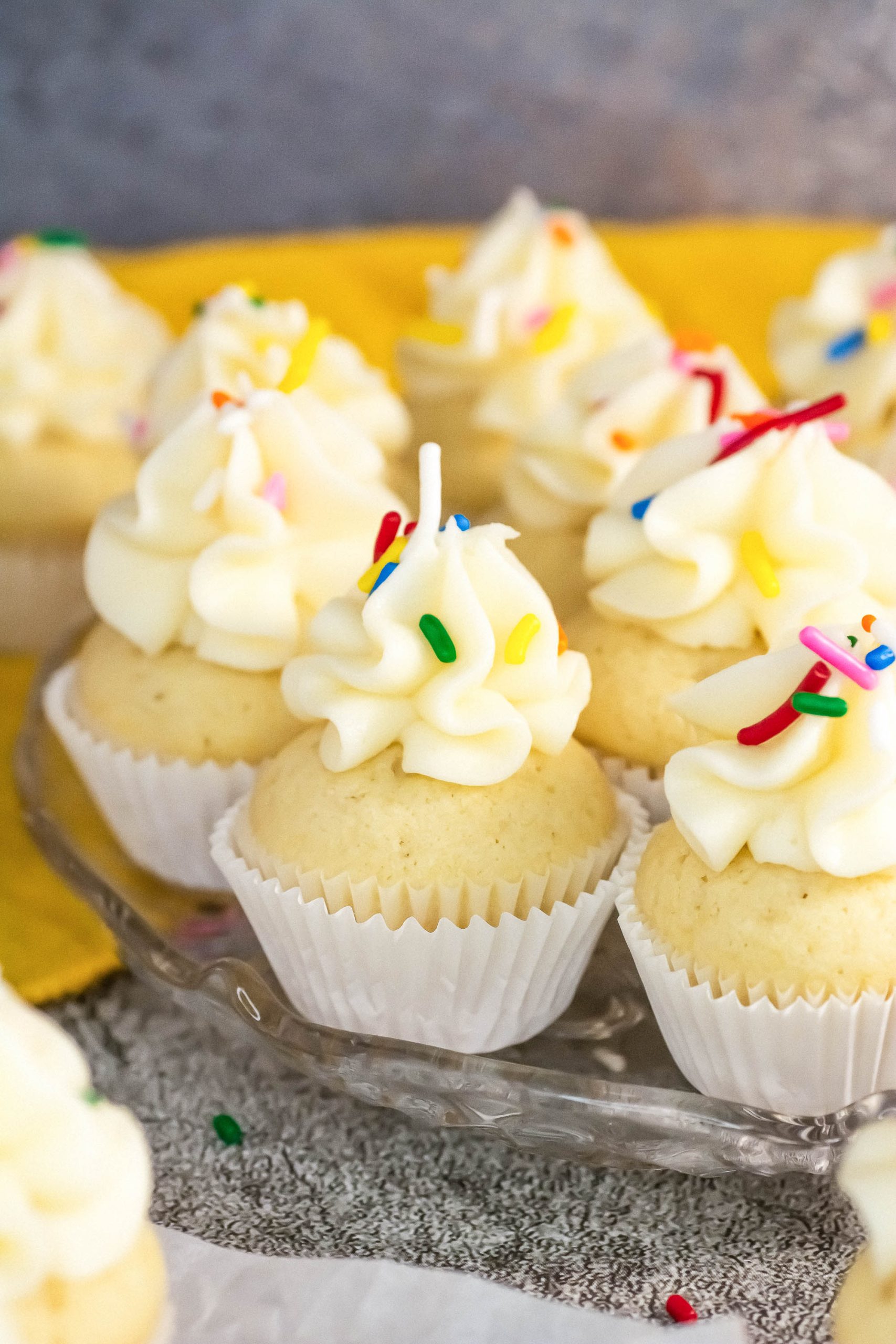 A group of Classic Vanilla Cupcakes with frosting on top.