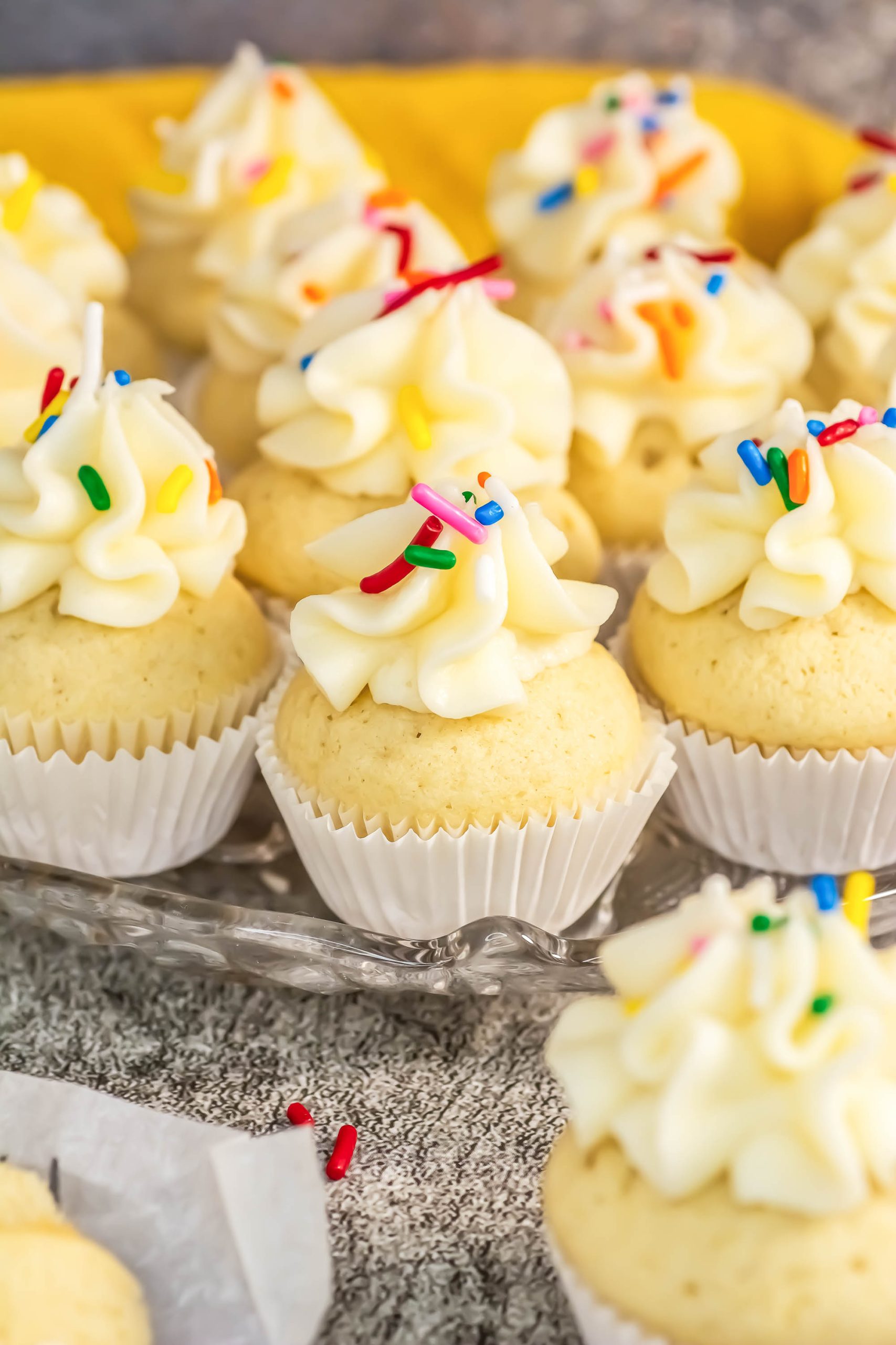 A tray of cupcakes with frosting and sprinkles.