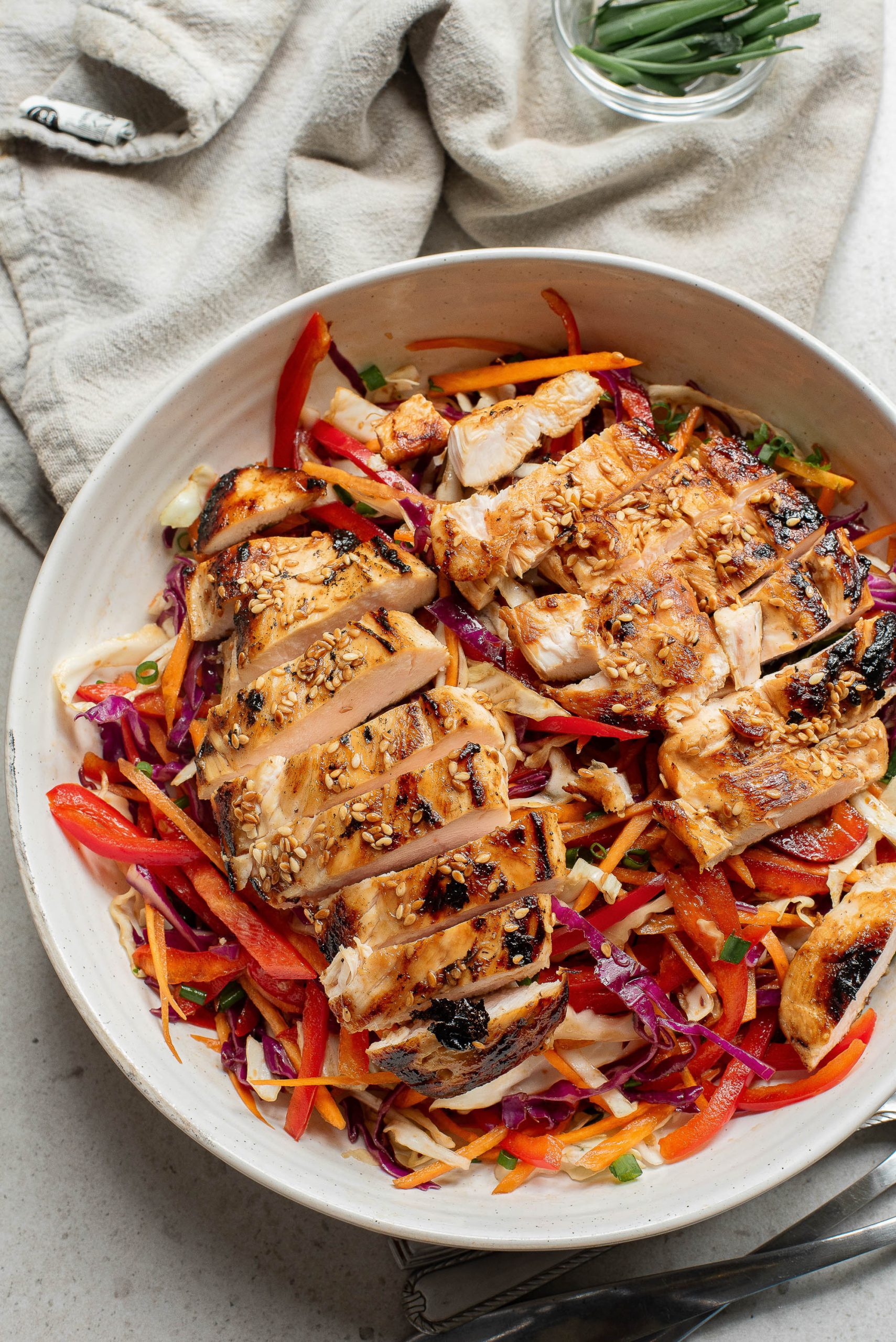 A bowl of Crunchy Sesame Chicken Salad on a table.