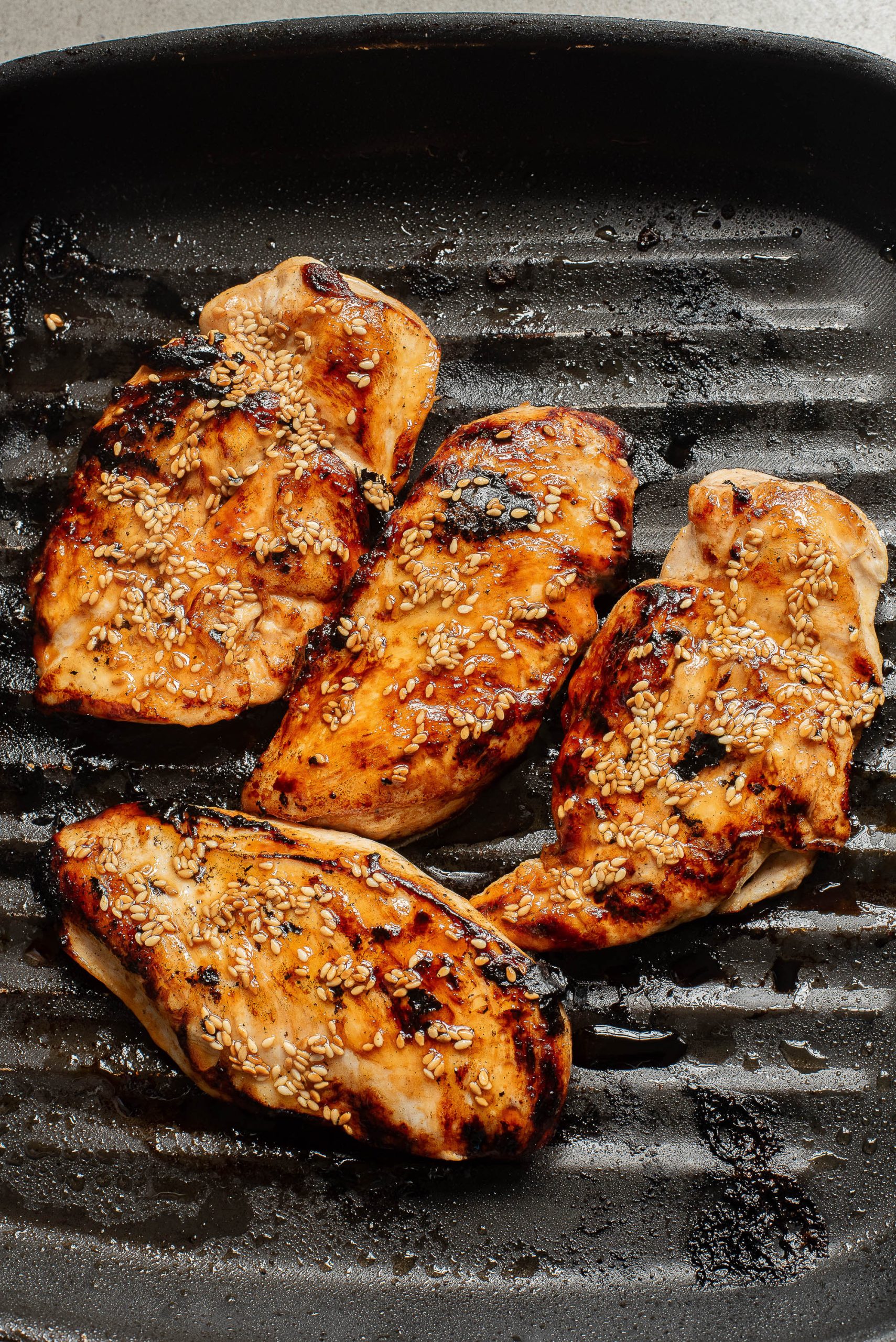 A group of chicken breasts on a grill.