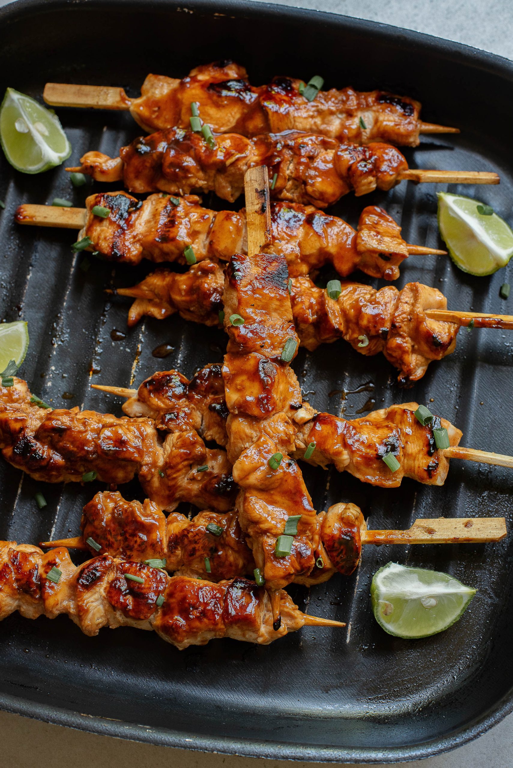 A skewers of Honey Beer Chicken Kabobs limes on a grill.