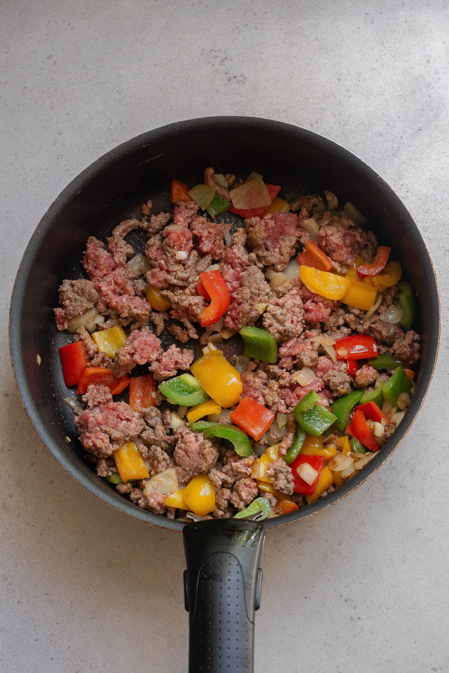 A frying pan filled with meat and vegetables.