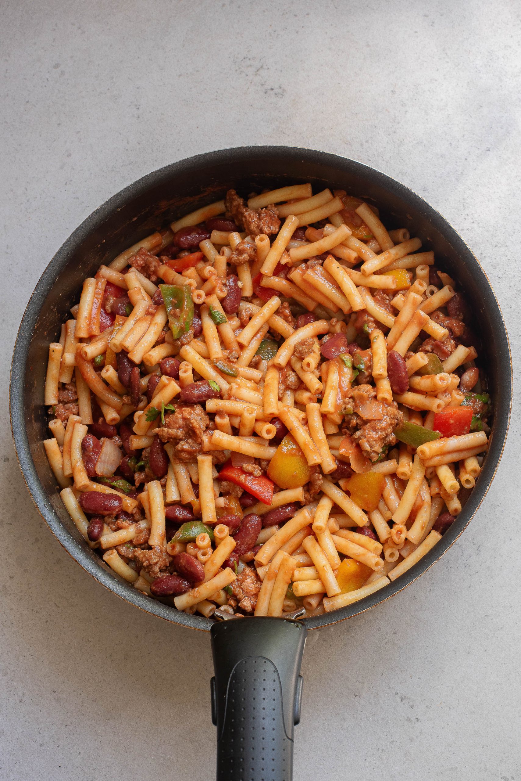 A frying pan filled with pasta and meat.