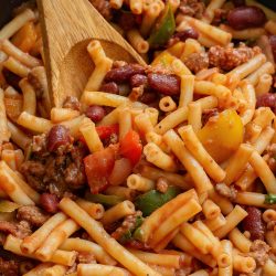 A skillet filled with pasta, meat and beans.