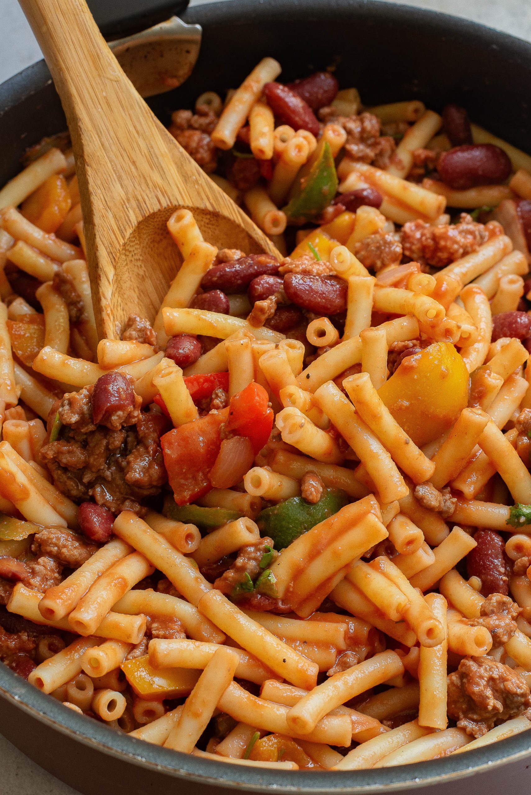 A skillet filled with pasta, meat and beans.