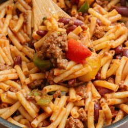 A skillet filled with pasta, meat and beans.