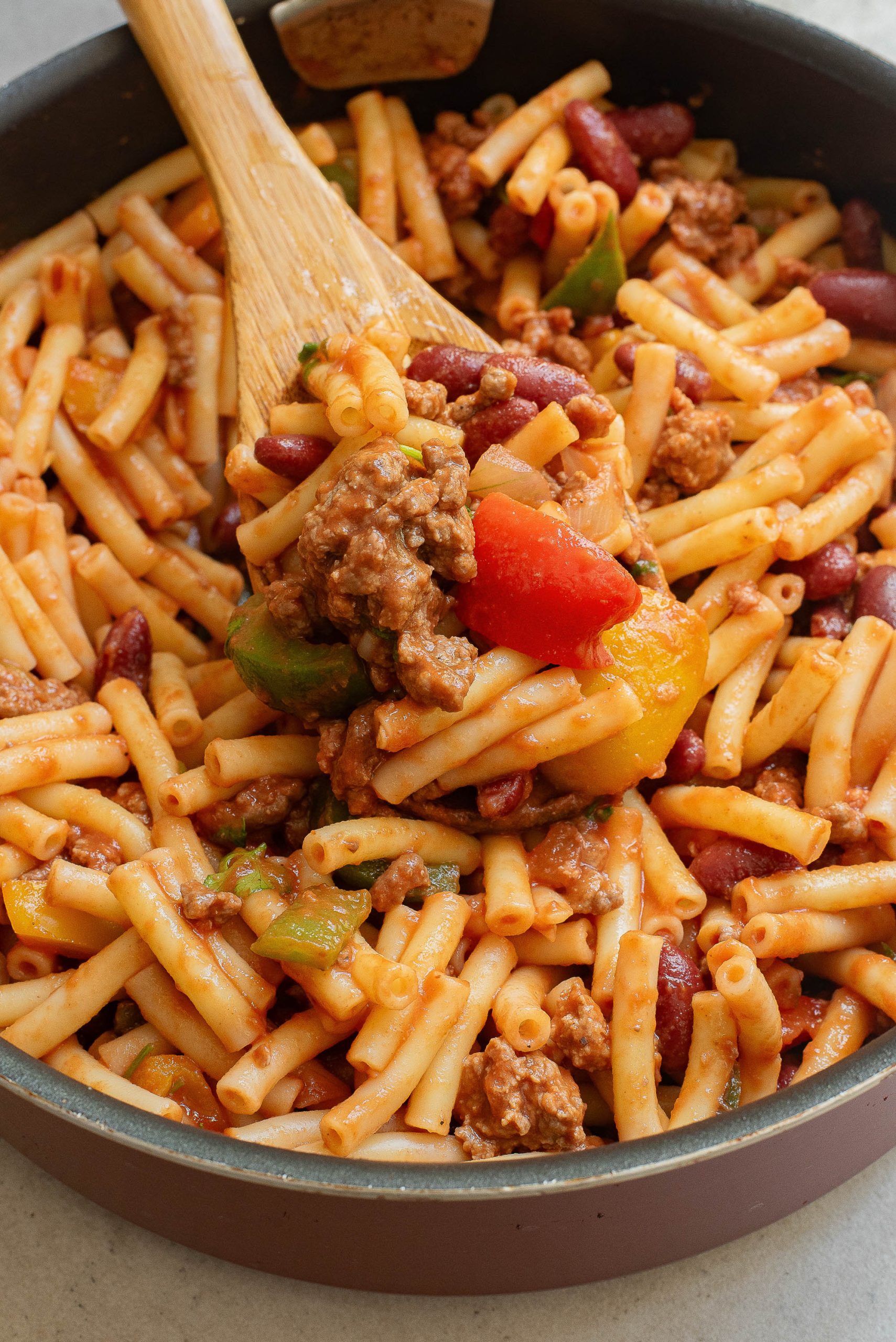 A skillet filled with pasta, meat and beans.