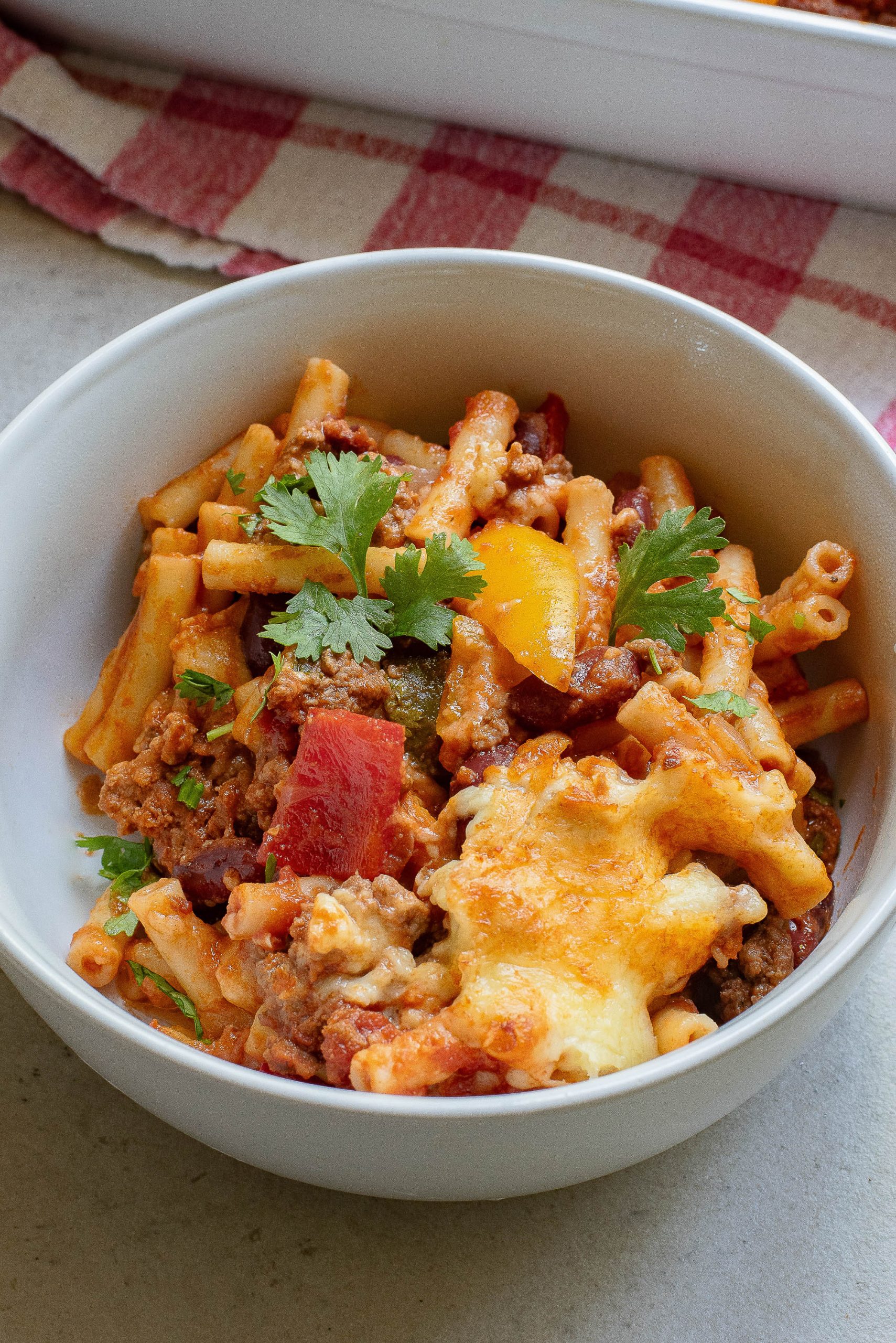 A bowl of pasta with meat and vegetables in it.