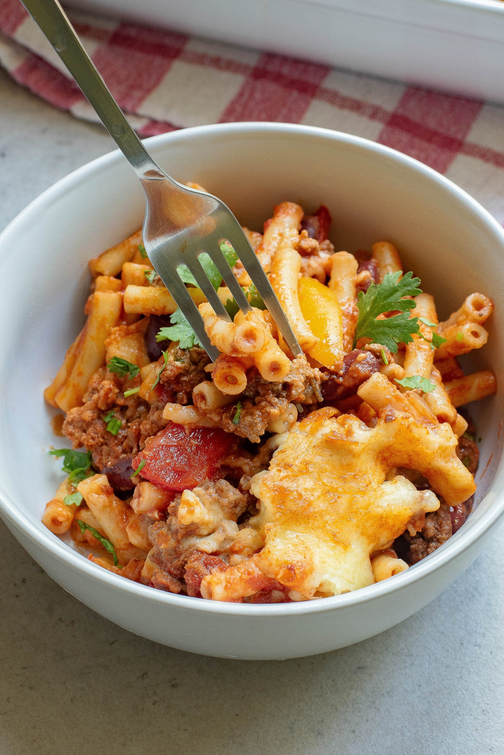 A bowl of pasta with meat and cheese in it.