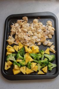 Chicken and pineapple on a baking sheet.