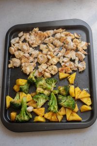 A pan with chicken, broccoli and pineapple on it.