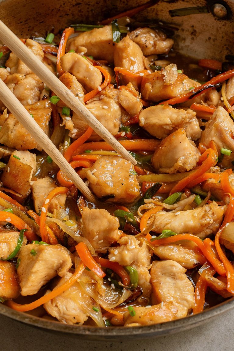 Chinese chicken stir fry in a pan with chopsticks.