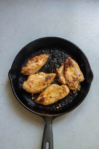 Grilled chicken breasts in a cast iron skillet.